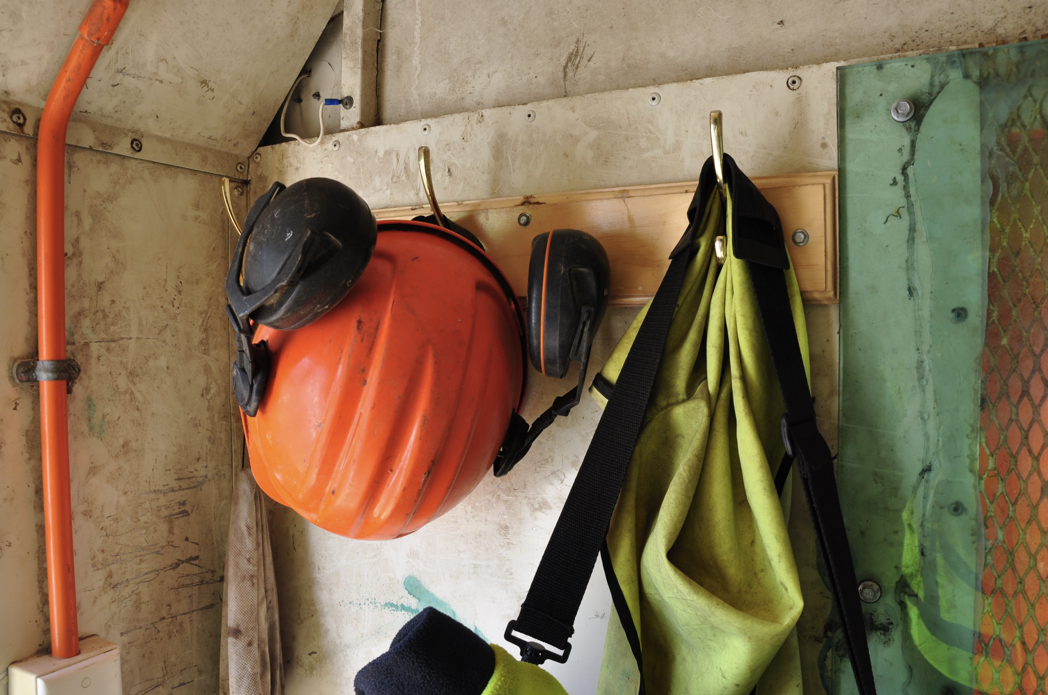 Forestry helmet and earmuffs hanging up on a hook